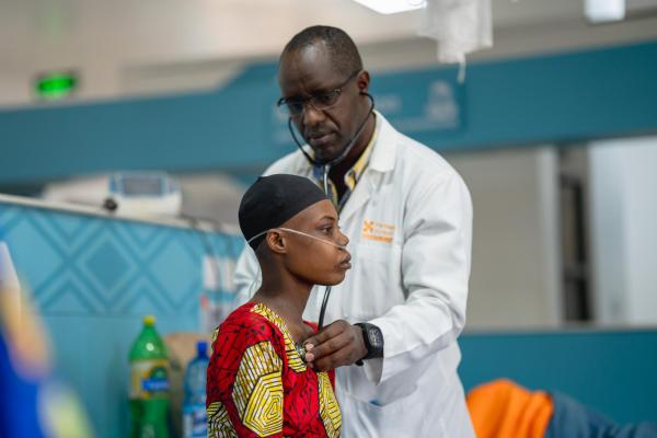 a medical oncologist listening to patient heartbeat