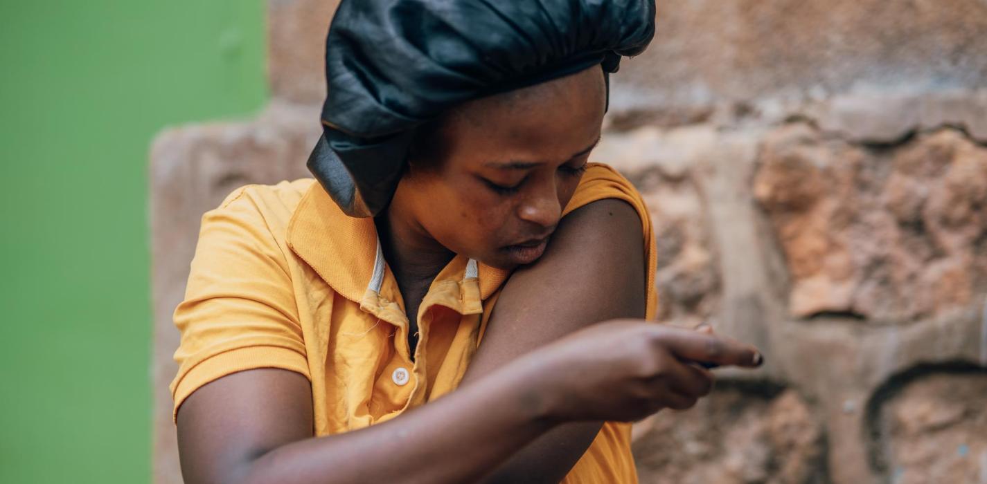 Woman in Rwanda giving herself medication