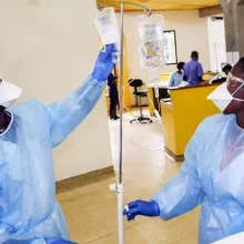 Nurse at Butaro District Hospital prepares IV Fluids for cancer patients